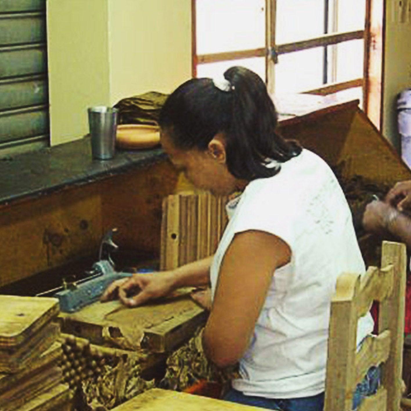 A woman rolling a cigar.