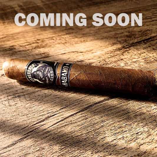 A cigar with a wrapper that has The Silverback Club logo on it of a gorilla smoking a cigar with the words "Habano". The words "Coming Soon" are over top of the cigar.