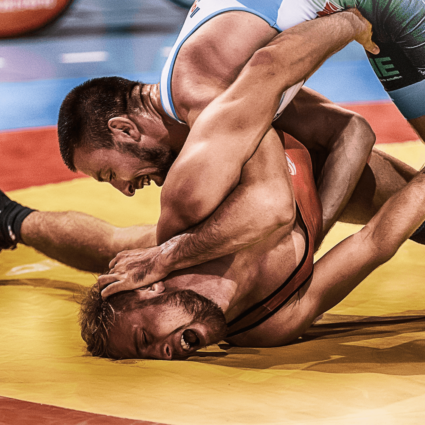 Two men wrestling on a mat.