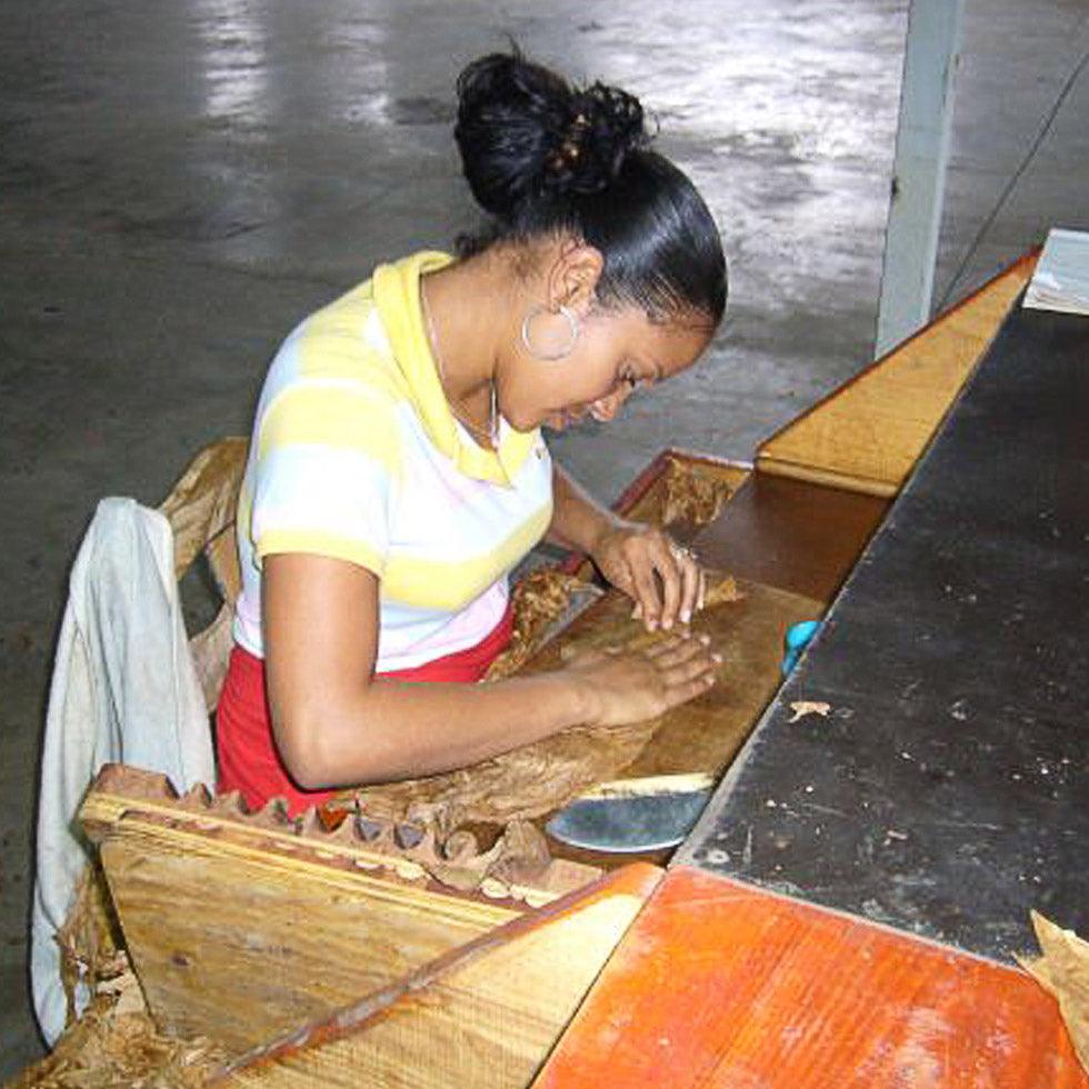 A woman rolling a cigar.